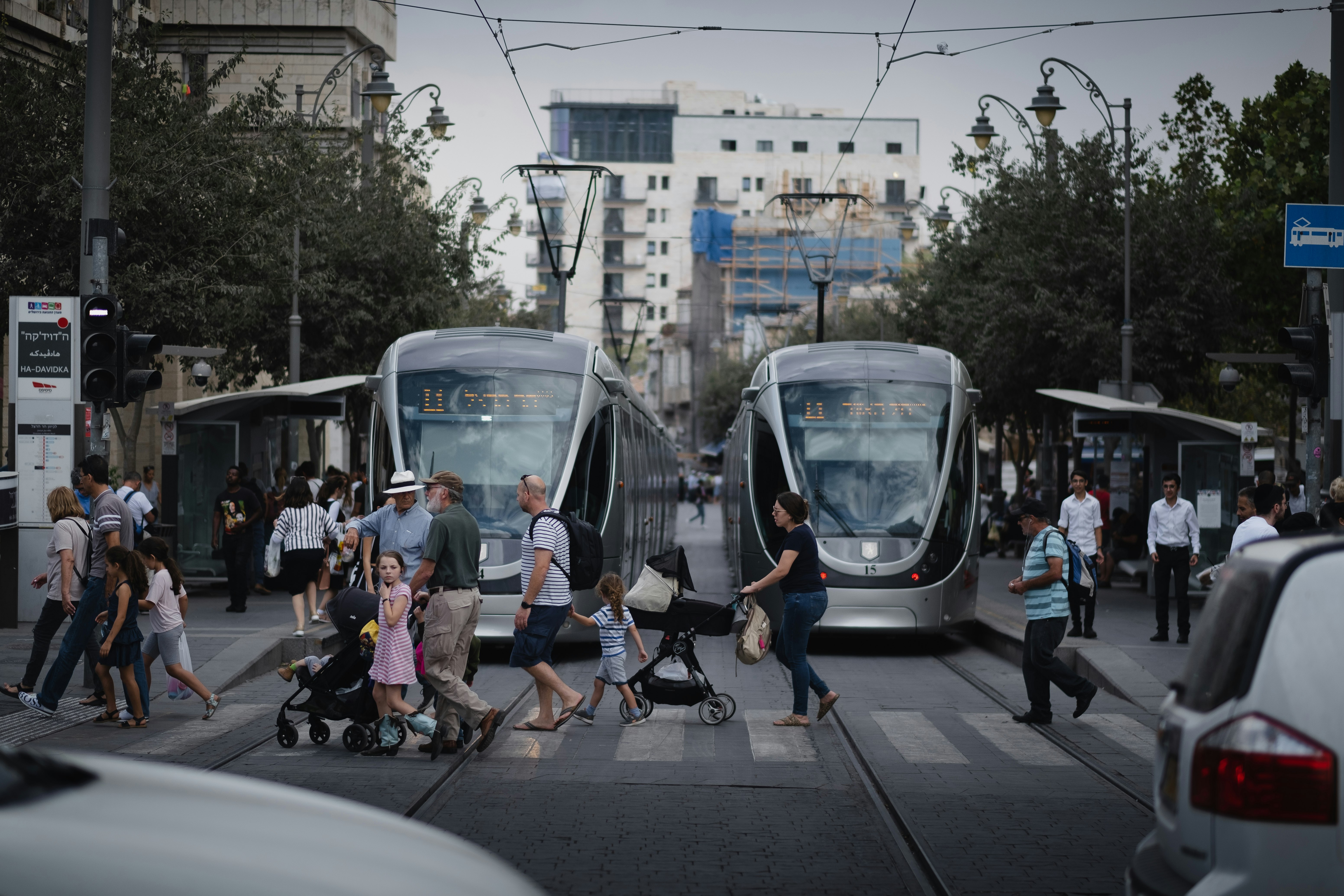 people walking on sidewalk near white train during daytime